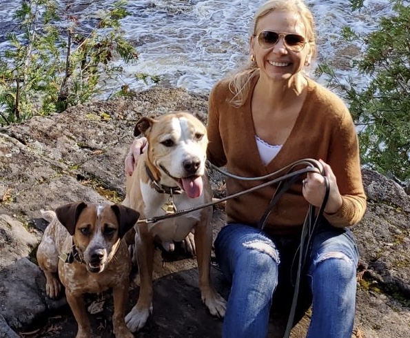 Joyce Pedicini posing with two dogs.